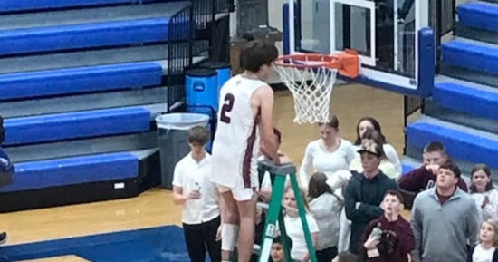 Cooper Shaw helps cut down the nets at Kearney High